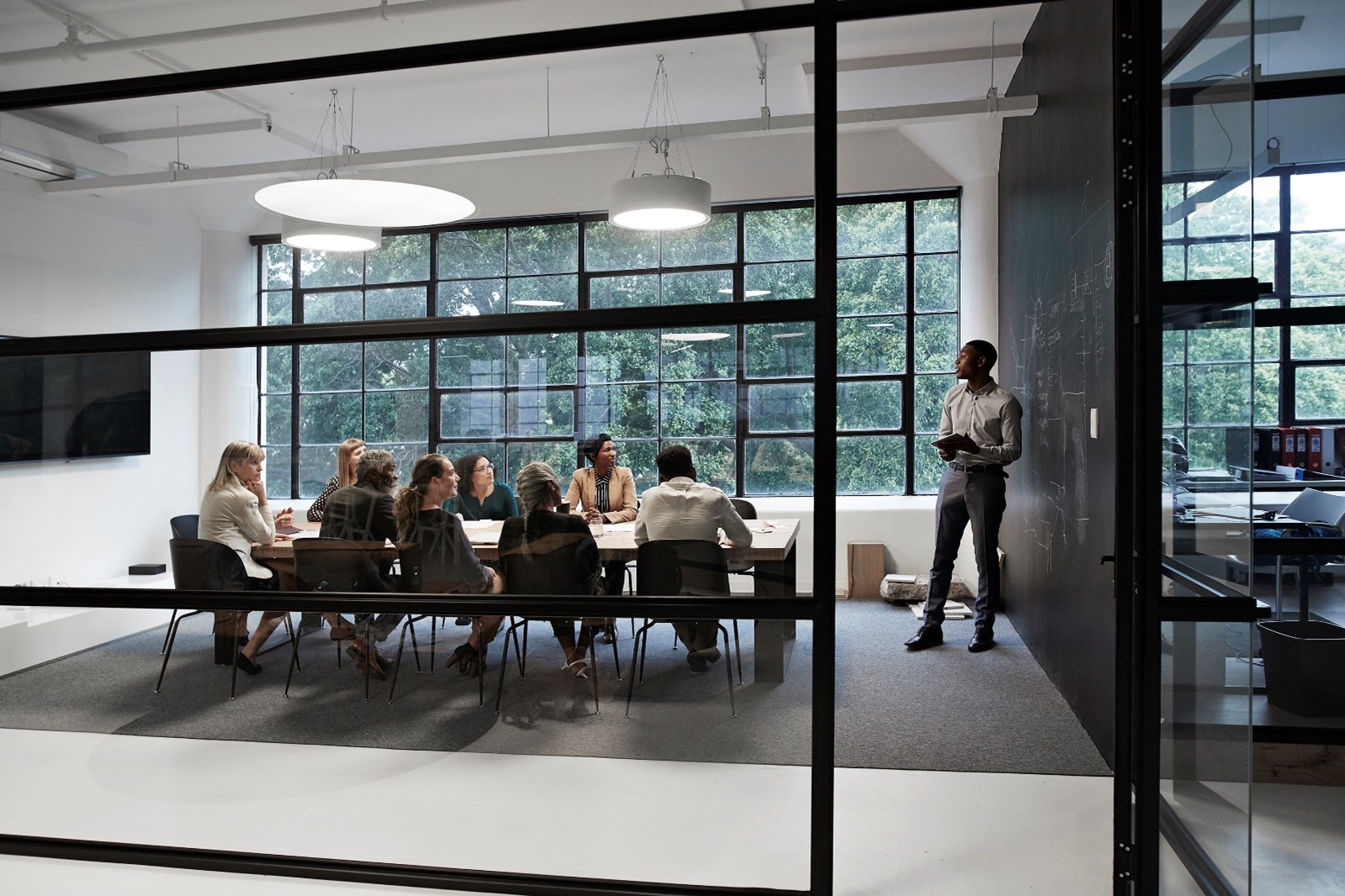 Image of a boardroom setting with a presenter leading a discussion focused on leadership coaching, engaging a group of leaders in a valuable learning lesson